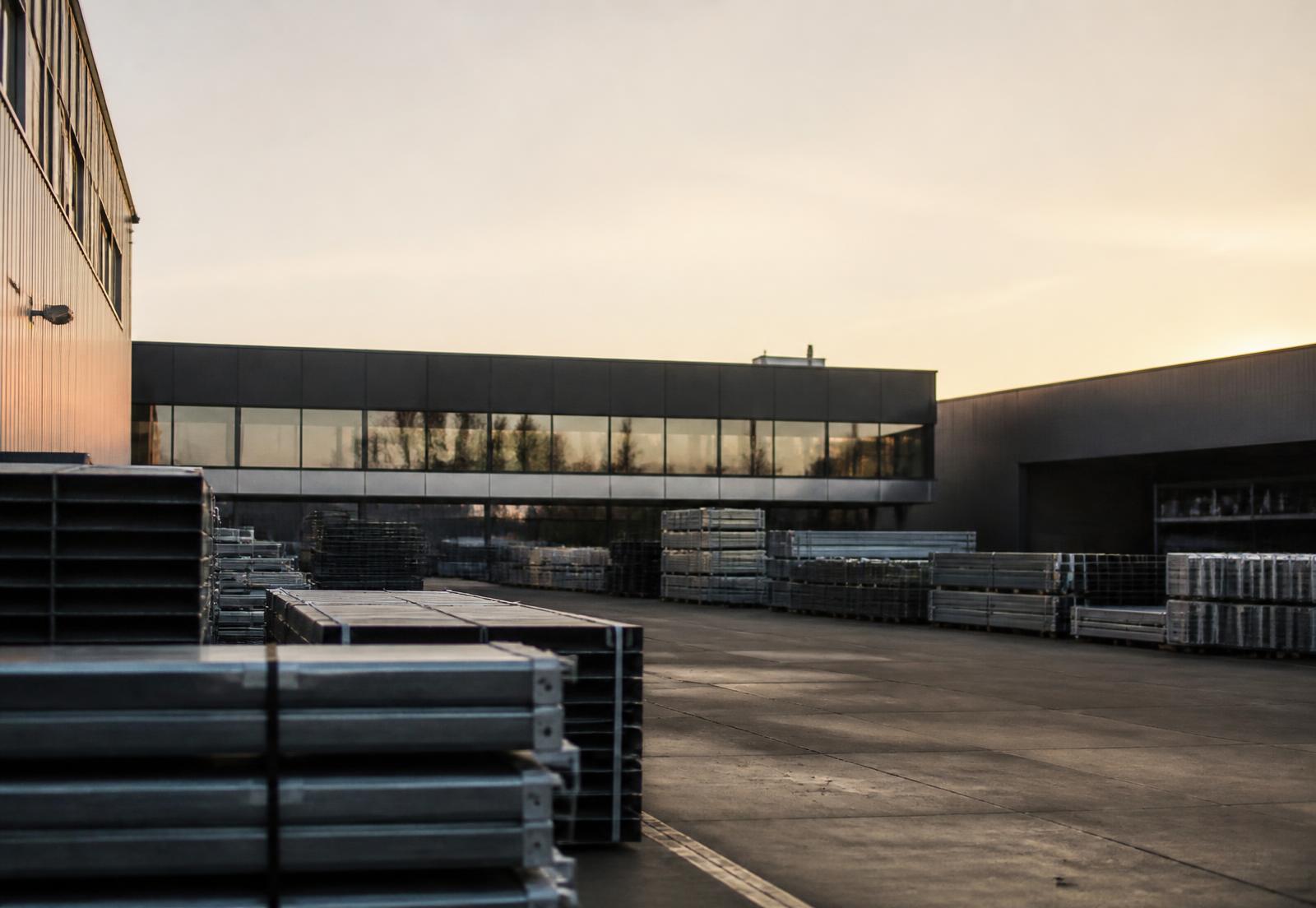 European manufacturing facility at dawn with stacked steel profiles in the loading yard